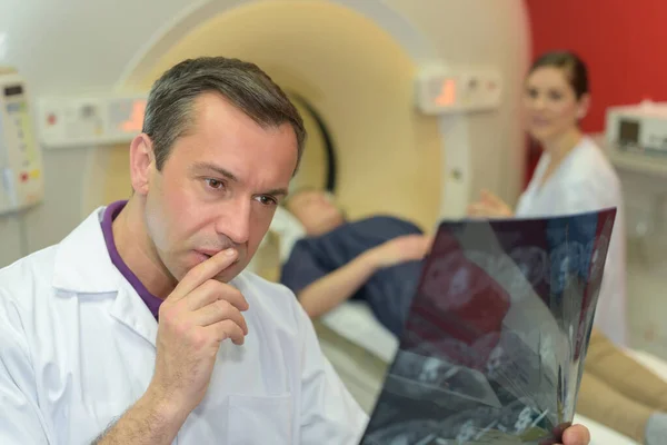 Pensive Doctor Studying Xray Patient Scanner Background — Stock Photo, Image