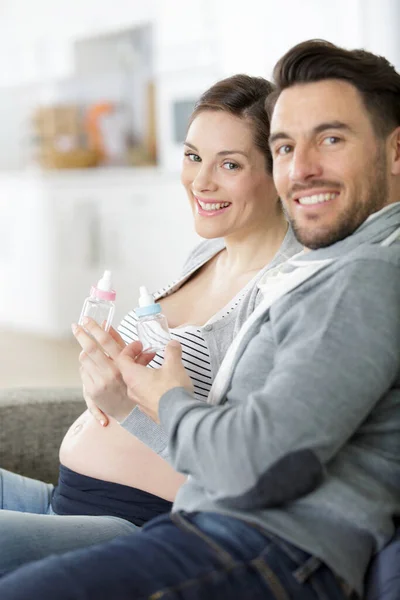 Young Couple Pregnant Woman Looking Presents Children Clothes — Stock Photo, Image