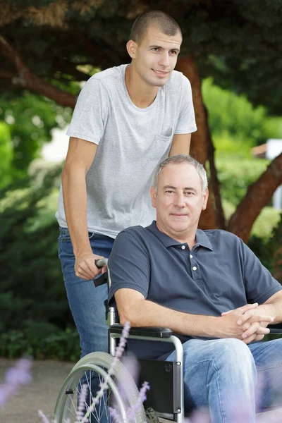 Oğlu Babası Tekerlekli Sandalyede Oturuyor — Stok fotoğraf