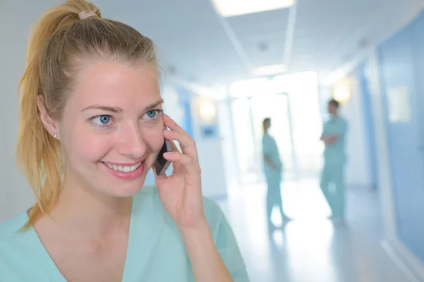 happy nurse with smartphone at hospital