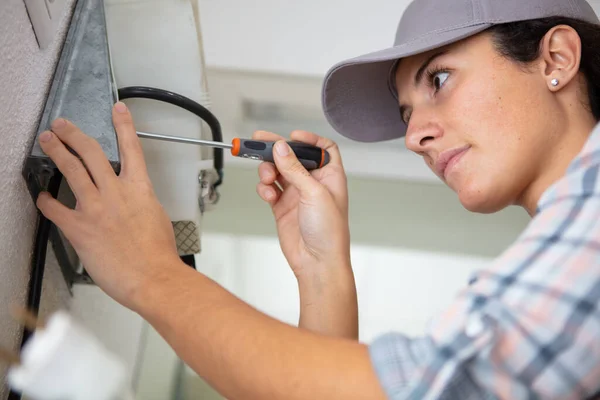 Woman Fixing Wall Applliance — Stock Photo, Image