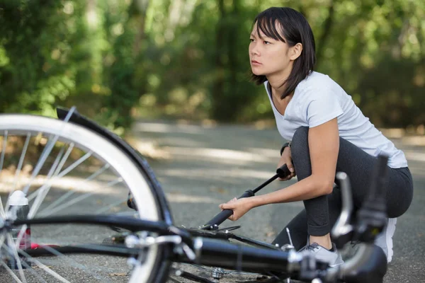 Jovem Mulher Bombeando Pneu Bicicleta Livre — Fotografia de Stock