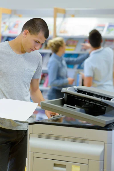 Young Male Student Using Photocopier — Stock Photo, Image