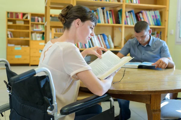 Two People Reading Table Library Woman Wheelchair — Stock Photo, Image