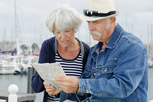 senior couple looking at map on traveling journey