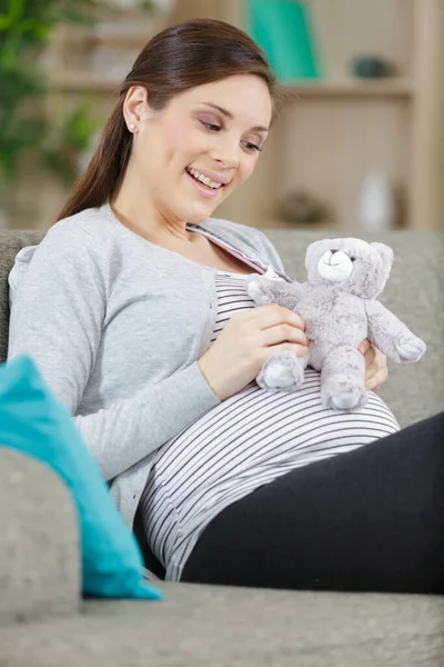 pregnant woman with toy teddy bear