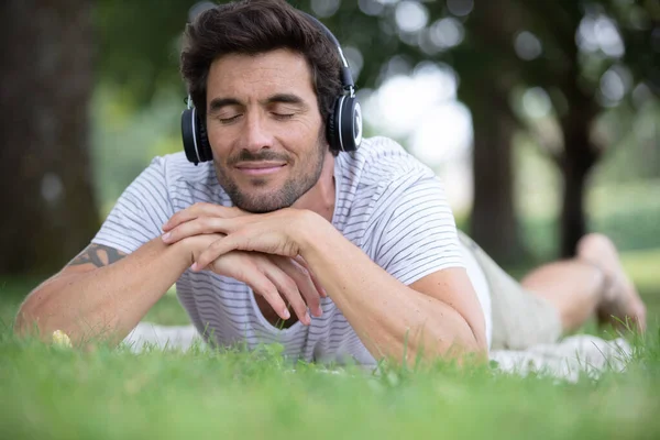 Νεαρός Άνδρας Που Ακούει Μουσική Στο Καταπράσινο Δάσος Του Καλοκαιριού — Φωτογραφία Αρχείου