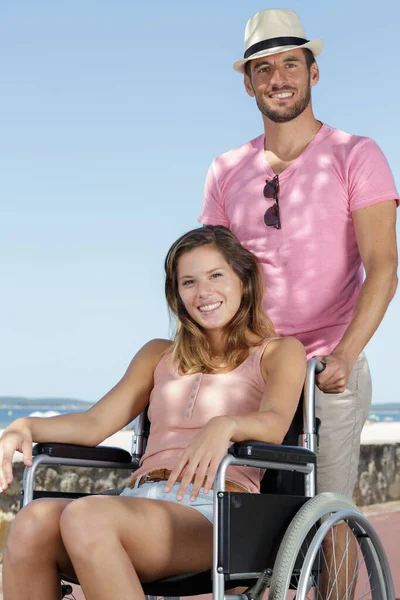 a man and a woman in wheelchairs outdoors