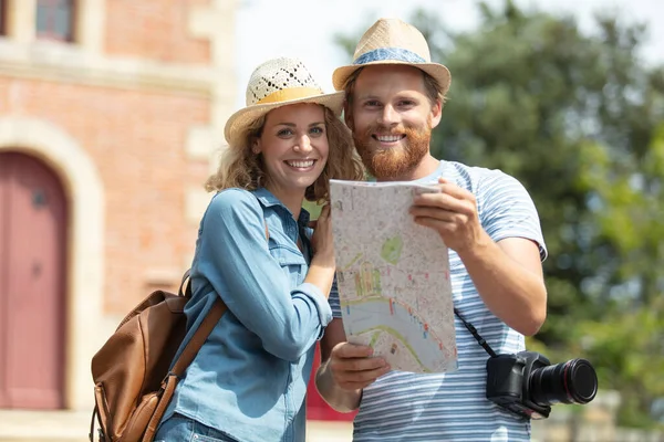 幸せな若いカップルの旅行者が手に地図を保持 — ストック写真