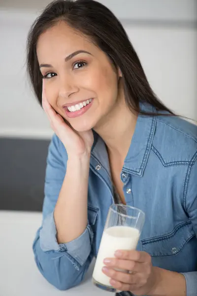 ミルクのグラスを握っている笑顔の女性 — ストック写真