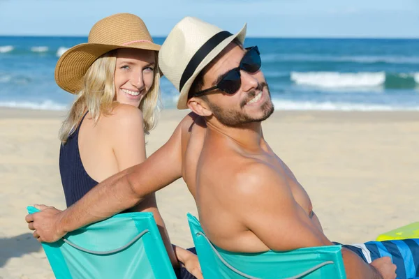 Junges Paar Strand Sitzt Lächelnd — Stockfoto