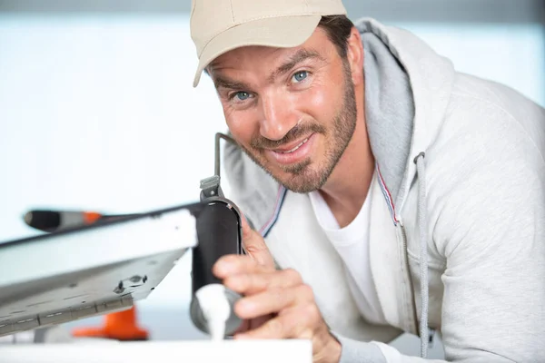 portrait of man installing kitchen hob