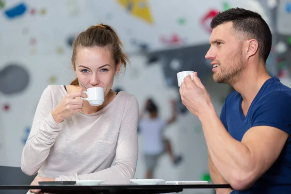 young couple havig coffee in an sports activity center
