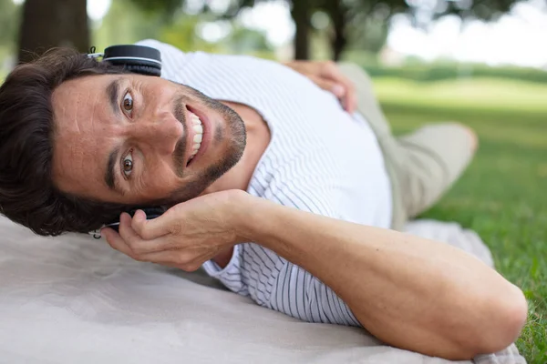 Homem Deitado Grama Ouvindo Música — Fotografia de Stock