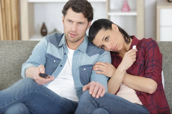 emotional couple watch television from the sofa