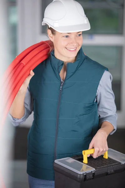 Female Worker Holding Reel Red Pipe Her Shoulder — Stock Photo, Image
