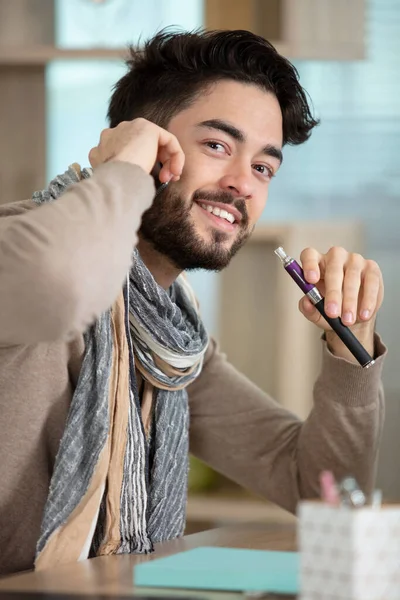 Young Man Holds Electronic Cigarette Talks Telephone — Photo