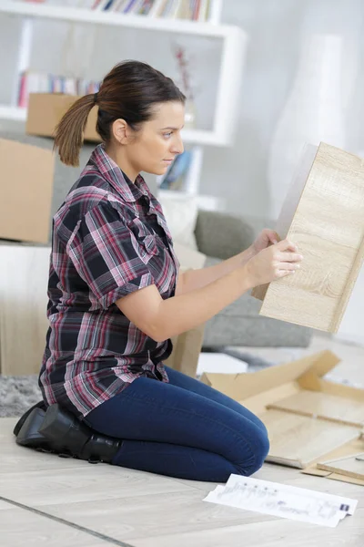 Side View Woman Knelt Floor Assembling Furniture — Stock Photo, Image