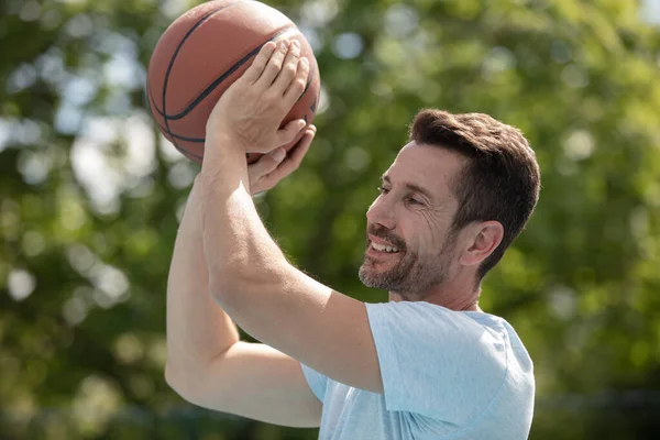 英俊的笑脸男人拿着篮球 — 图库照片