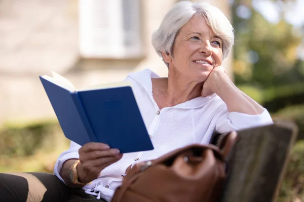 Mujer Jubilada Leyendo Libro Banco — Foto de Stock