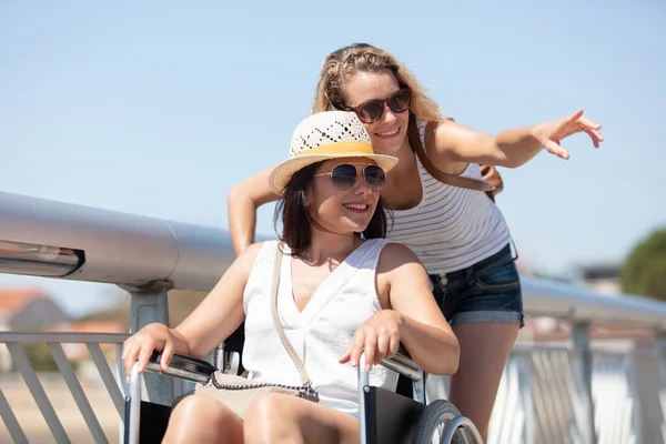 happy disabled woman with sister on a pier