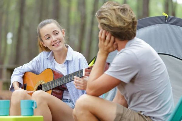 キャンプ場でボーイフレンドに歌う女性 — ストック写真