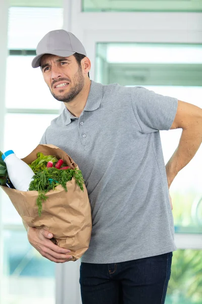 Young Deliveryman Standing His Hands Back — Stock Photo, Image