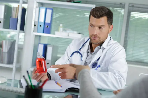 Doutor Mostrando Uma Garrafa Pílulas Para Paciente — Fotografia de Stock