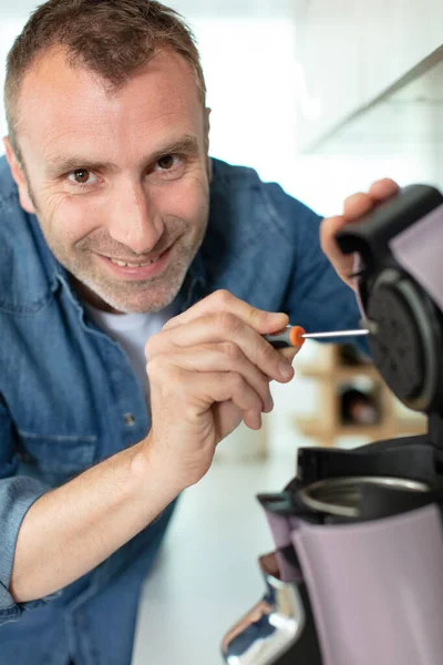 Happy Man Repairing Broken Coffee Machine — Stock Photo, Image