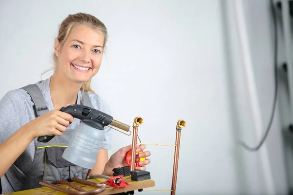 快乐的女人焊接鸡舍的管子 — 图库照片