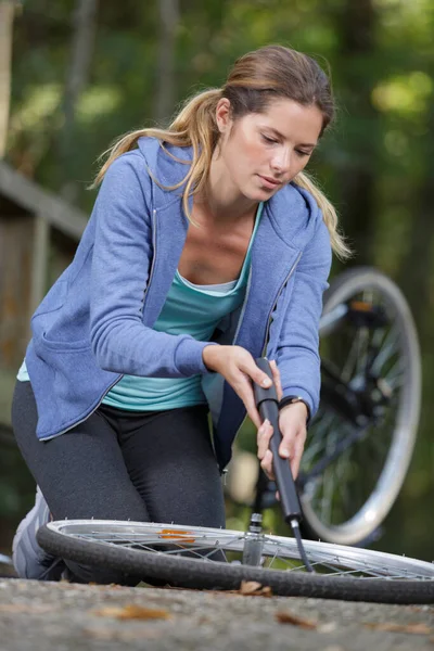Mujer Bombeando Neumático Bicicleta —  Fotos de Stock