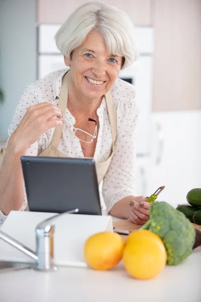 Starsza Kobieta Gotowanie Pomocą Receptury Tabletkę — Zdjęcie stockowe