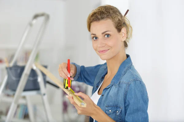 woman measuring furniture with tape measure
