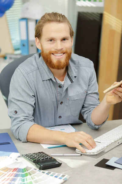 a man with the calculator and computer in office