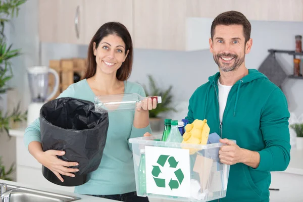 couple separating rubbish at home for recycling