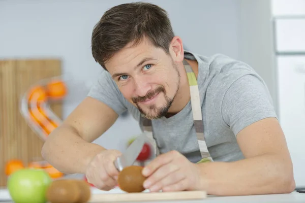 年轻人的手在切菜板上切西红柿 — 图库照片