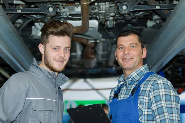 Zwei Männliche Mechaniker Arbeiten Unter Auto Zusammen — Stockfoto