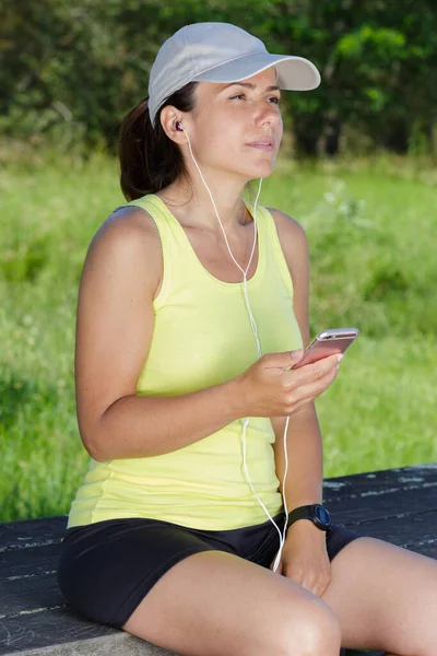 woman runner sitting using a smart phone