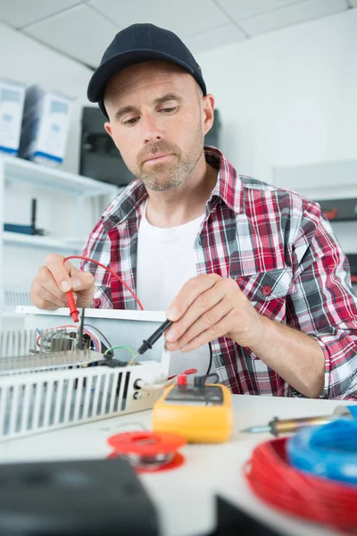 Eletricista Masculino Verificando Aquecedor Com Multímetro Digital — Fotografia de Stock