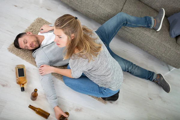 Vrouw Gevonden Dronken Man Liggend Vloer Met Lege Flessen — Stockfoto