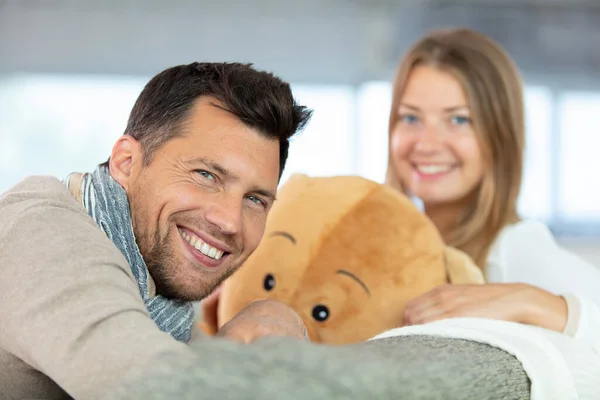 Young Couple Hugging Teddy Bear While Sitting Couch — Stock Photo, Image