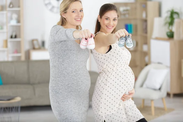 Gravida Kvinnor Som Visar Babyskor — Stockfoto