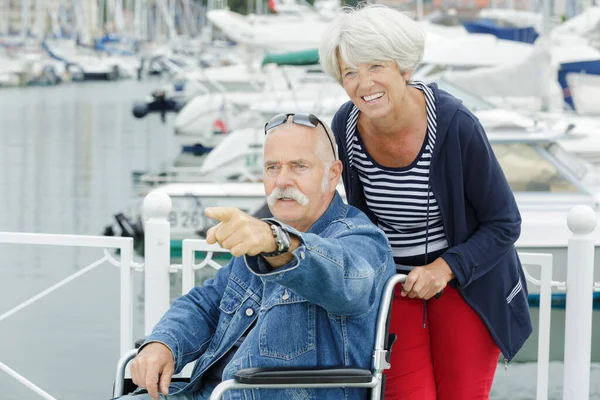 senior couple on holiday man in wheelchair