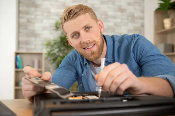 young energetic male tech or engineer repairs electronic equipment