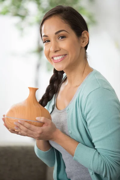 beautiful woman holding an essential oil diffuser