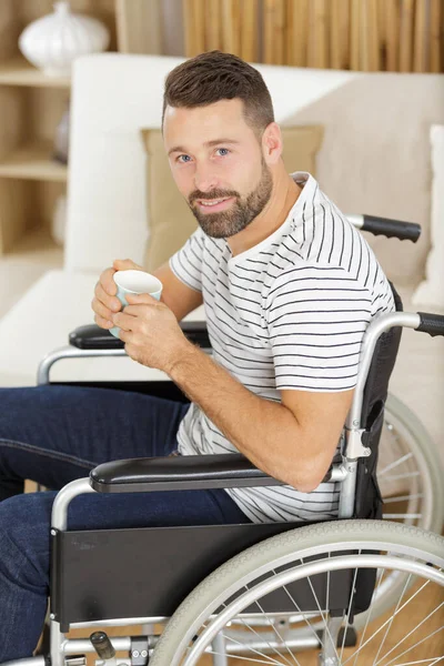 Fröhlicher Behinderter Sitzt Rollstuhl Und Trinkt Tee — Stockfoto