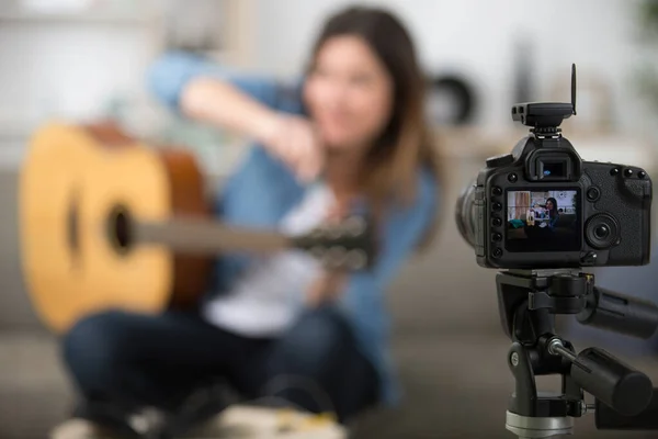 female guitar player recording creative musical vlog