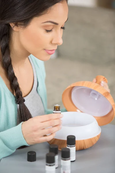 woman with her eyes closed smelling oils