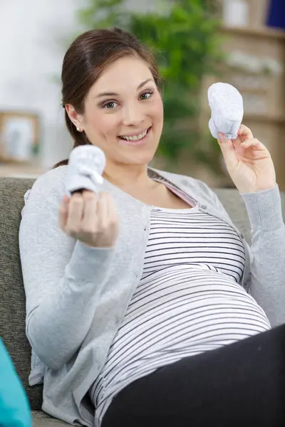 Pregnant Woman Holding Small Baby Shoes Relaxing Home — Stock Photo, Image