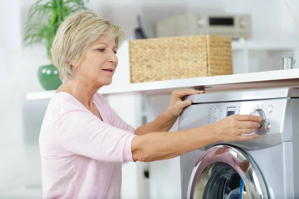 Senior Woman Loading Washing Machine Home — Stock Photo, Image